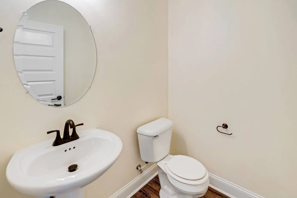 This image displays a serene bathroom with a sink, mirror, and toilet, offering a sense of calm and routine. The clean and organized setup hints at the presence of high-quality facilities for personal care and refreshment.